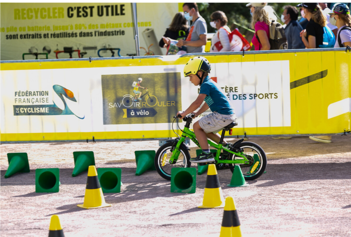 Petit garçon roulant à vélo lors des ateliers L'avenir à vélo organisés pendant le Tour de France
