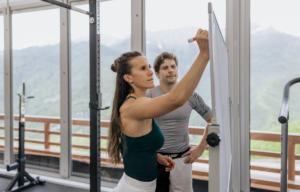 Sportive qui écrit sur un tableau à côté de son coach